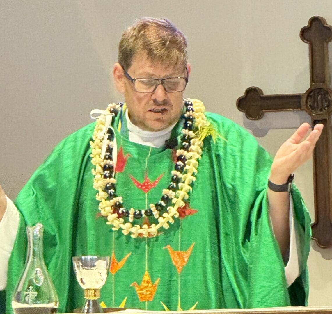 Priest in green vestments giving blessing.